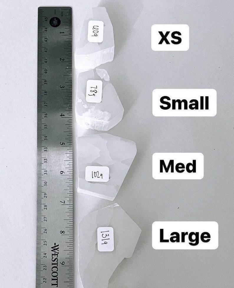 May include: Four white selenite crystals of varying sizes labeled XS, Small, Med, and Large. The crystals are measured in inches using a ruler.