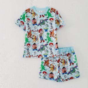 K&ouml;nnte beinhalten: Hellblaues zweiteiliges Pyjama-Set mit einem Aufdruck verschiedener Toy Story-Charaktere. Das Set besteht aus einem kurz&auml;rmeligen Oberteil und passenden Shorts. Das Oberteil hat einen Rundhalsausschnitt und die Shorts haben einen elastischen Bund.