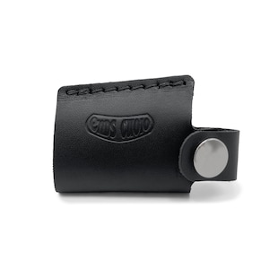 May include: Black leather key fob with a silver button and the embossed text "ems audio".