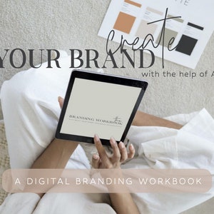 May include: A person using a tablet computer to work on a digital branding workbook. The text on the screen reads "Branding Workbook". The text on the page reads "Create Your Brand with the help of AI. A Digital Branding Workbook."