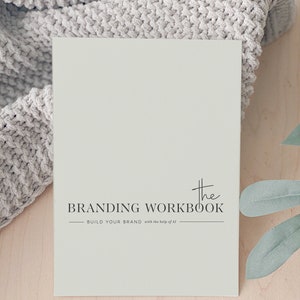 May include: A light green branding workbook with the text "The Branding Workbook - Build Your Brand with the help of AI" printed on the front.