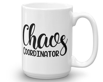 以下が含まれることがあります： 黒い文字で「Chaos Coordinator」と書かれた白いセラミック製のコーヒーカップです。
