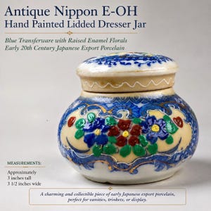 May include: Antique Nippon E-OH hand-painted lidded dresser jar. The blue transferware jar features raised enamel florals. It is approximately 3 inches tall and 3 1/2 inches wide. Early 20th Century Japanese Export Porcelain.
