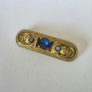 Jolie broche avec pierres et strass gris et noir sur métal doré qualité
