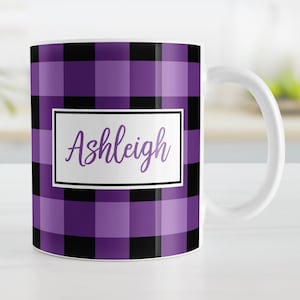 May include: Purple and black buffalo plaid mug with the name Ashleigh in a white box.