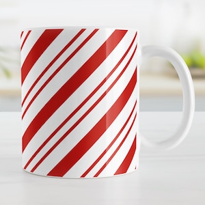 May include: White ceramic mug with a red and white candy cane stripe pattern.