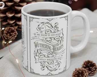 May include: White ceramic mug with a black handle. The mug has a vintage design with a green and white floral pattern and the text "Wuthering Heights - We are bound by our desire - Emily Bronte 1847".