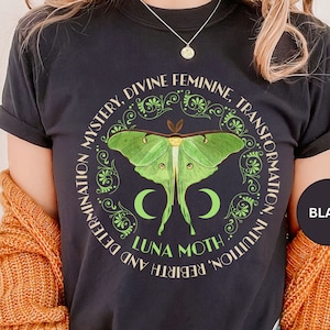 May include: Black t-shirt with a green luna moth graphic and the text "Rebirth and Determination, Mystery, Divine Feminine, Transformation, Intuition" in a circle around the moth.