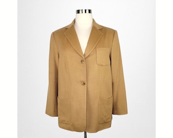 Könnte beinhalten: Ein brauner Blazer mit einem einzigen Knopfverschluss und zwei Taschen. Der Blazer hat eine klassische, taillierte Passform.