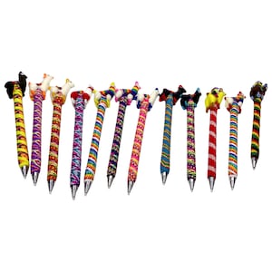 May include: A set of 12 colorful pens with animal toppers. The pens are wrapped in colorful yarn and have silver metal tips. The animal toppers include a llama, a chicken, a bird, and a dog.