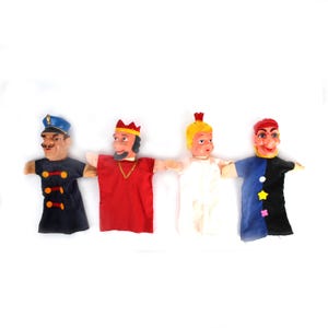 May include: Four vintage hand puppets. The puppets feature painted faces and fabric clothing. The puppets include a police officer, a king, a child in white, and a jester. They are arranged in a row against a white background.