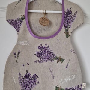 Può includere: Una borsa di tela riutilizzabile a tema lavanda con un bordo viola e un'etichetta marrone che dice "mit liebe handgemacht". La borsa è realizzata in lino e presenta un motivo di fiori di lavanda e il testo "Herbes de Provence" e "Lavender".