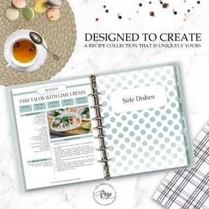 May include: A blue and white polka dot recipe binder with a recipe for Fish Tacos with Lime Crema. The binder has tabs for different categories of recipes, including seafood, side dishes, main dishes, desserts, bread, soups, salads, and meatless.