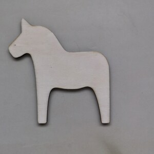 May include: A white wooden Dala horse cutout, a traditional Swedish folk art design.
