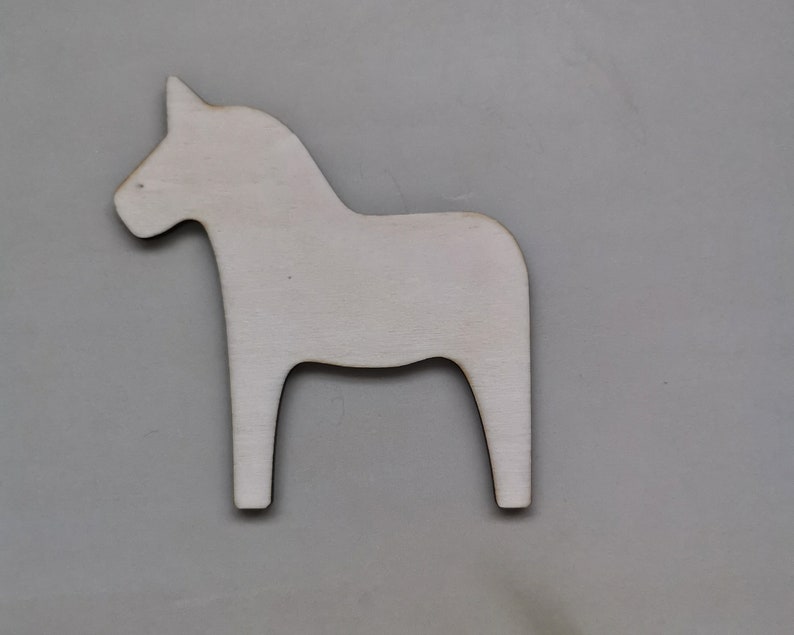 May include: A white wooden Dala horse cutout, a traditional Swedish folk art design.