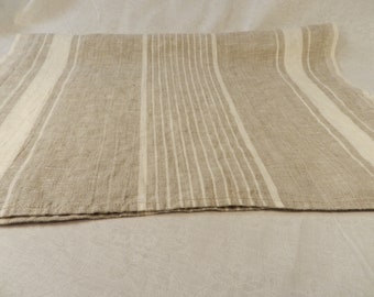 May include: A natural linen table runner with white stripes. The runner is folded in half and has a subtle texture.