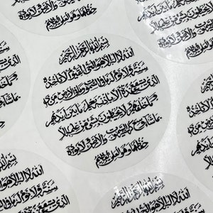 May include: A sheet of white stickers with a black Arabic script. The stickers are round and have a clear, glossy finish.