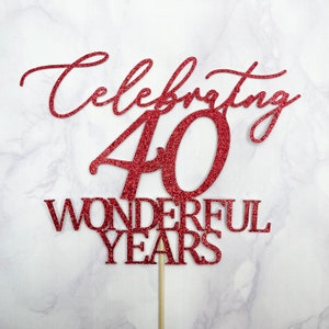 Könnte beinhalten: Roter Glitzer-Kuchentopper mit dem Text "Celebrating 40 Wonderful Years".