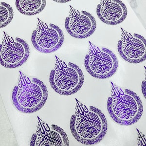 May include: A collection of purple stickers featuring Arabic calligraphy. Each sticker has a teardrop shape with intricate script within a circular border. The stickers are arranged on a white surface, creating a pattern.
