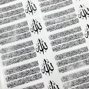 May include: A sheet of rectangular stickers featuring black Arabic calligraphy. Each sticker displays the Ayatul Kursi verse alongside the word Allah in a distinct, larger script. The design is repeated in a grid pattern across the white surface.