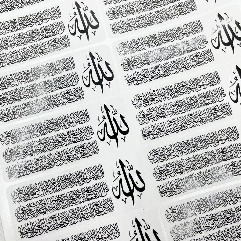May include: A sheet of rectangular stickers featuring black Arabic calligraphy. Each sticker displays the Ayatul Kursi verse alongside the word Allah in a distinct, larger script. The design is repeated in a grid pattern across the white surface.