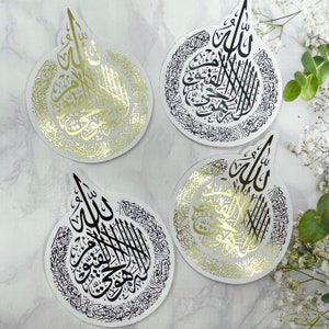 May include: Four circular stickers with Arabic calligraphy in gold and black. The stickers have a white background and a unique teardrop shape at the top. The calligraphy is intricate and detailed, with a decorative border.