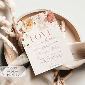 May include: A bridal shower invitation with floral accents and the words "Love in Bloom." The invitation features a soft color palette of blush, cream, and green, with the text "Digital - or - Printed."