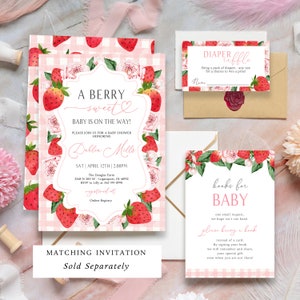 Op de afbeelding: Een set briefpapier voor een babyshower met een aardbeienthema. De uitnodiging luidt "A Berry Sweet Baby is on the Way!" en bevat details. Andere kaarten bevatten een luierloterij en een verzoek om boeken. Roze en wit geruit patroon.