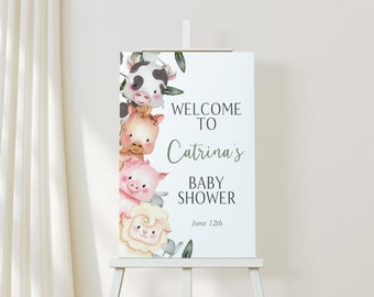 May include: A white sign on an easel with the text "Welcome to Catrina's Baby Shower" and the date June 12th. The sign features watercolor illustrations of a cow, pig, sheep, and other farm animals.