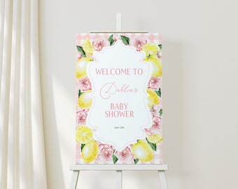 May include: A pink and white gingham background with a white frame and text that reads "Welcome to Dahlia's Baby Shower June 12th". The frame is surrounded by watercolor illustrations of lemons, pink peonies, and green leaves.