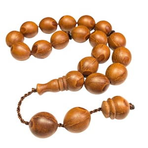 May include: A brown wooden prayer beads or rosary with a tassel. The beads are oval shaped and have a natural wood grain pattern.