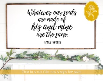 May include: A white sign with a black calligraphy quote that reads "Whatever our souls are made of, his and mine are the same." The quote is attributed to Emily Bronte. The sign is framed in a rustic brown wood frame.