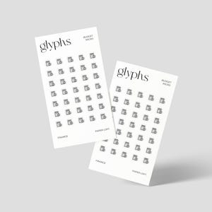 May include: Two white paper sheets with the word "glyphs" at the top, featuring rows of small black icons of a document with a checkmark. The text "BUDGET MICRO" and "FINANCE PAPER LOFT" are also visible. The sheets are slightly angled.