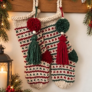 May include: Two hand-knitted Christmas stockings featuring a cream, red, and dark green geometric pattern. Each stocking is adorned with a large yarn pom-pom and a matching tassel, suspended by a cream loop from a wooden hook.