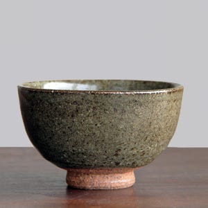 Könnte beinhalten: Eine handgefertigte Keramikschale mit einer gesprenkelten, olivgrünen Außenseite und einem rötlich-braunen Sockel. Die Schale hat einen leicht ausgestellten Rand und eine strukturierte Oberfläche, ideal für Suppen oder Eintöpfe.