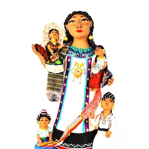 May include: A ceramic figurine of a woman with four children. The woman is wearing a white dress with colorful embroidery and a purple sash. She is holding a child in her arms. The other children are standing around her. The figurine is painted in bright colors.