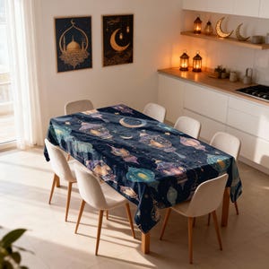 Könnte beinhalten: Eine marineblaue Tischdecke mit einem Muster aus bunten Laternen, Monden und Sternen. Die Tischdecke ist über einem Holztisch mit sechs beigen Stühlen drapiert. Zwei gerahmte Bilder hängen an der Wand.