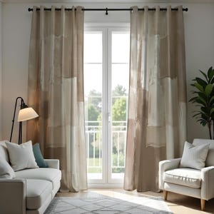 Può includere: Tende a fantasia astratta beige e bianca appese davanti a una porta bianca. Le tende presentano un design a strati con forme rettangolari beige chiaro e scuro e bianche. Un divano e una poltrona bianchi sono davanti.