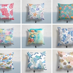 Peut inclure: Neuf designs de coussins différents mettant en scène diverses créatures marines, notamment des coraux, des coquillages, des étoiles de mer, des hippocampes et des tortues. Les coussins sont tous blancs avec des motifs colorés.