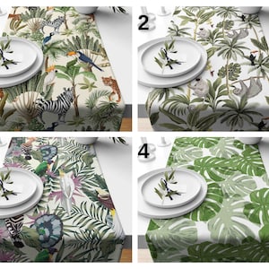 May include: Four different table runner designs featuring tropical jungle patterns. The designs include a white background with green palm trees, monkeys, sloths, and toucans, a white background with green leaves and exotic birds, a white background with green leaves and zebras, and a white background with large green monstera leaves.