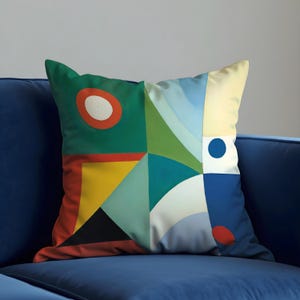 May include: Square decorative pillow with a geometric design. The pillow features a patchwork of colors including green, yellow, blue, and red. The design includes circles, triangles, and other shapes.