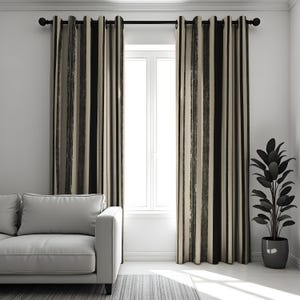 Puede incluir: Un par de cortinas rayadas en negro y crema con un sutil patrón de pinceladas. Las cortinas están colgadas de una barra de cortina negra con terminales plateados.