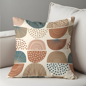 May include: Square throw pillow with a cream background and a repeating pattern of abstract shapes in shades of brown, teal, and pink. The design includes half-circle and dot patterns, creating a modern, geometric aesthetic.