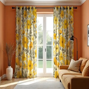 Puede incluir: Cortinas con estampado floral con un diseño de flores amarillas y grises. Las cortinas cuelgan frente a una ventana, con un sofá y una lámpara en la habitación. Las cortinas están hechas de una tela suave y están diseñadas para bloquear la luz.
