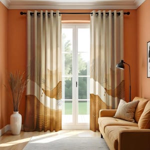 Puede incluir: Cortinas beige y marrón con diseño de paisaje. Las cortinas cuelgan de una barra negra y enmarcan una puerta blanca. Un jarrón con plantas secas está a la izquierda. Un sofá y un cojín color canela están en primer plano.