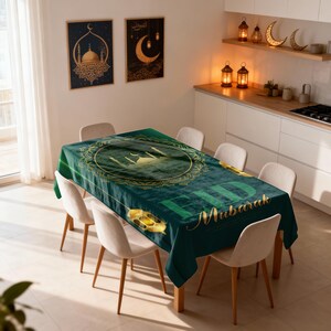 以下が含まれることがあります： 金色のアクセントと「EID Mubarak」の文字が金色の緑色のテーブルクロス。テーブルクロスは、円形のフレームに金色のモスクのデザインが特徴です。ダイニングルームには、6つの椅子がセットされたテーブルがあります。