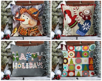 Könnte beinhalten: Vier verschiedene Weihnachtskissen-Designs. Das erste Kissen zeigt einen Schneemann mit einem rot-orangenen Schal und einem blauen Vogel. Das zweite Kissen zeigt eine rot-weiße Mütze, eine blaue Mütze und eine Tasse heiße Schokolade. Das dritte Kissen zeigt einen grauen Hintergrund mit dem Wort "Frohe" und "Weihnachten" in verschiedenen Weihnachts-Symbolen. Das vierte Kissen zeigt ein buntes Patchwork-Design mit roten, grünen, blauen und gelben Kreisen und Quadraten.
