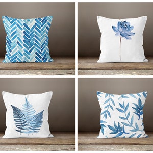 Könnte beinhalten: Vier verschiedene blaue und weiße Kissenbezüge. Das erste Kissen hat ein blaues und weißes Chevron-Muster. Das zweite Kissen hat eine blaue Aquarellblume. Das dritte Kissen hat einen blauen Aquarellfarn. Das vierte Kissen hat ein blaues Aquarellblatt-Muster.