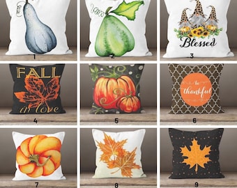 May include: A collection of nine decorative throw pillows with autumn-themed designs. The pillows feature watercolor illustrations of gourds, pumpkins, fall leaves, and gnomes. Some pillows have text that reads "Blessed", "Fall in love", and "be thankful".
