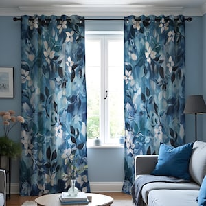 Puede incluir: Dos cortinas azules con estampado floral y ojales cuelgan de una barra negra. Las cortinas presentan un diseño de acuarela de flores blancas y hojas azul oscuro y grises sobre un fondo azul claro.
